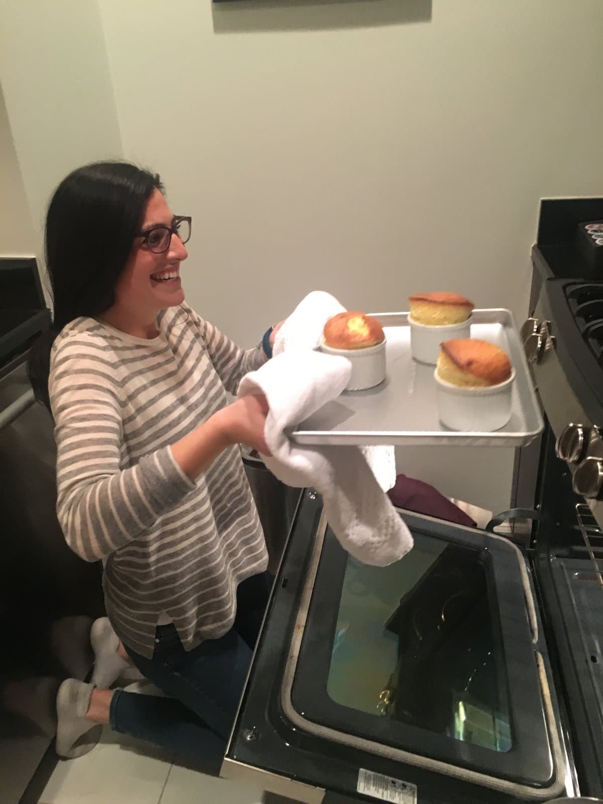 Sophie in her kitchen, pulling a tray of soufflés from the oven